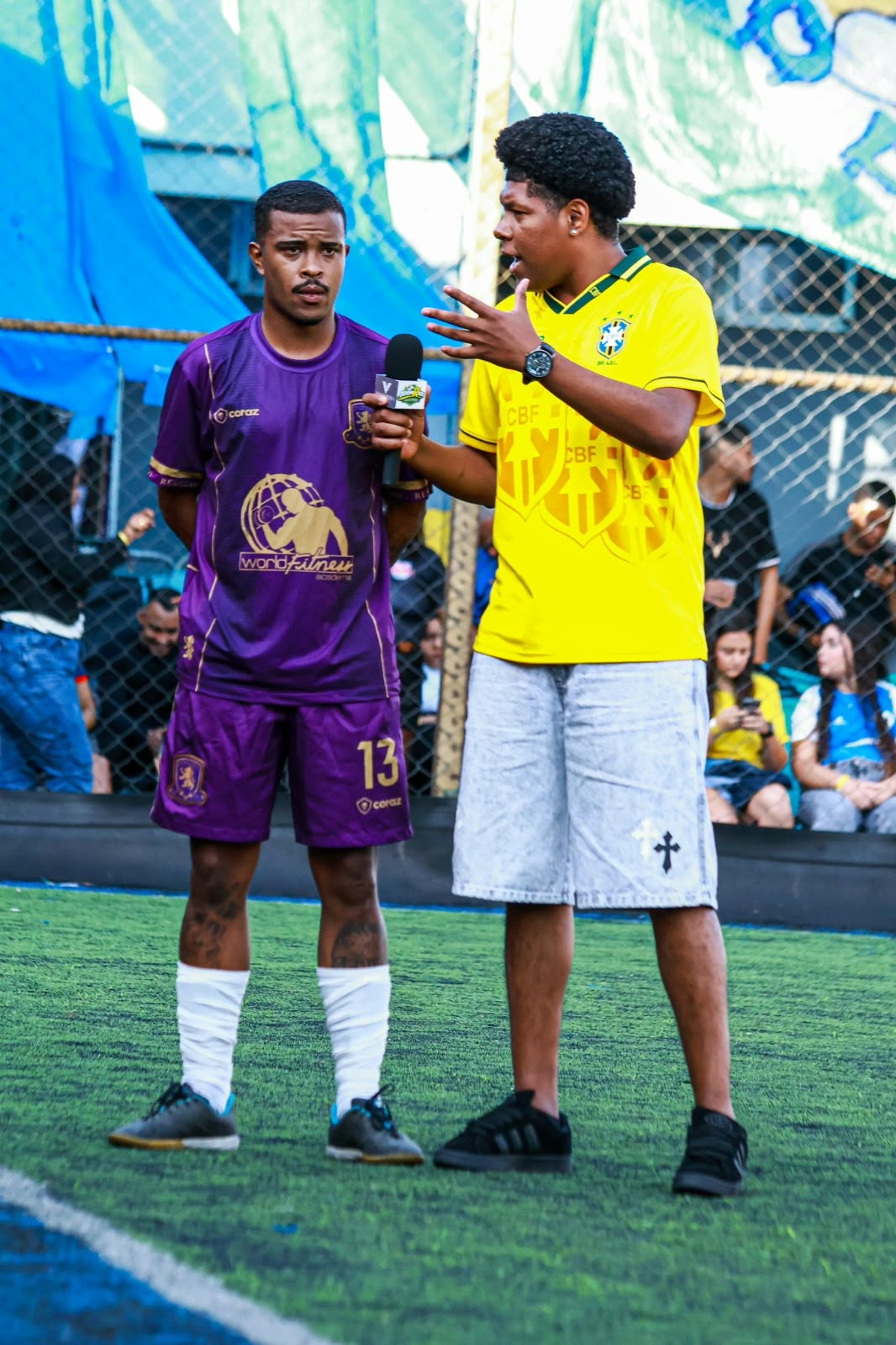 Teodoro durante uma entrevista com um jogador de uniforme roxo.